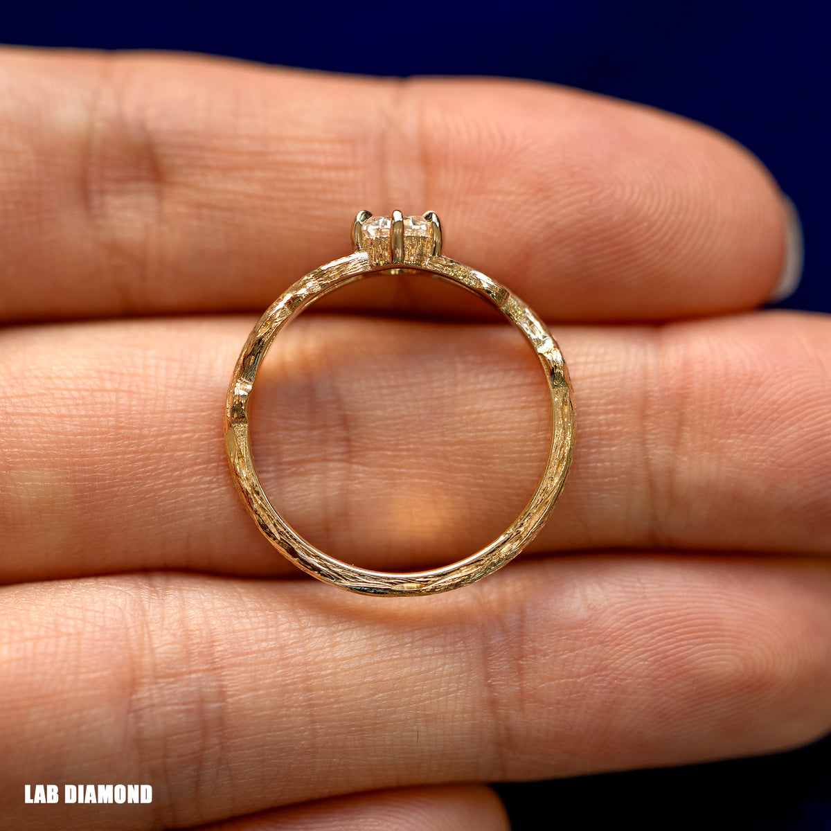 A yellow gold Lab Diamond Branches Ring in a model's hand showing the claw prong detailing and the whole ring