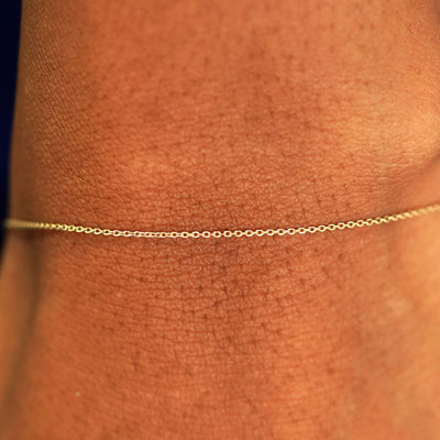 Close up view of a model's wrist wearing a solid 14k yellow gold Cable Bracelet