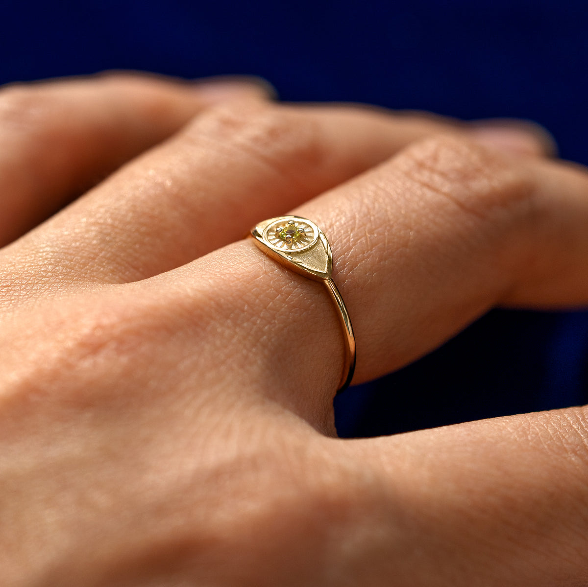 Side view of a Ruby Gemstone Evil Eye Ring on a model's finger