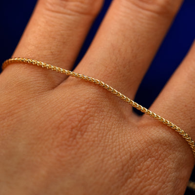 A yellow gold Mini Franco Chain Bracelet on the back of a model's hand to show the details of the links