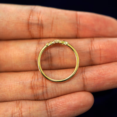 A yellow gold Thin Claddagh Ring in a model's hand showing the thickness of the band