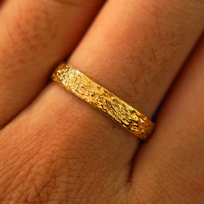 Close up view of a model's fingers wearing a 24k Band with a raw finish
