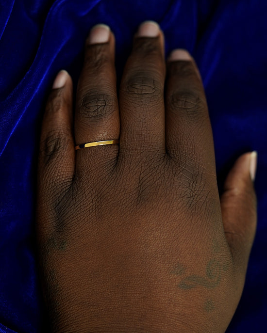 A hand wearing a 2mm band in size 14