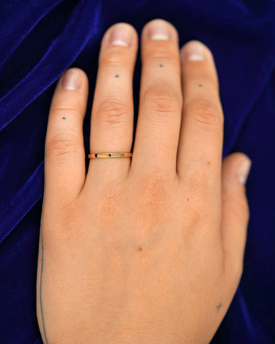 A hand wearing a 2mm band in size 6.5