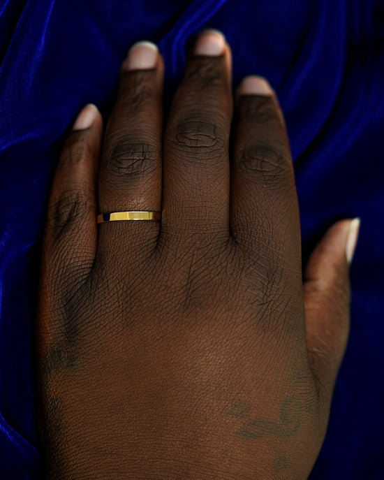 A hand wearing a 3mm band in size 14
