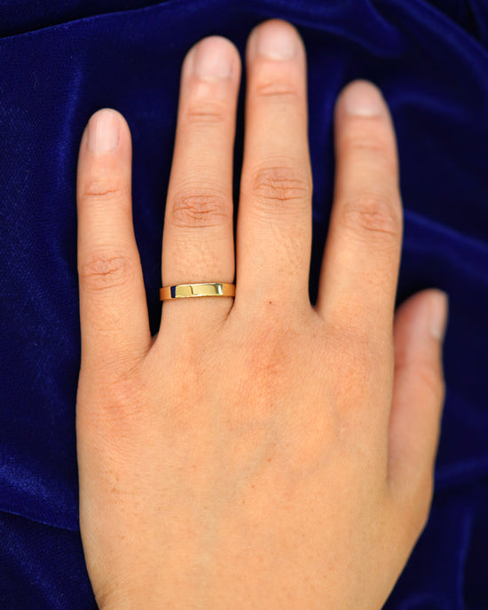 A hand wearing a 3mm band in size 4