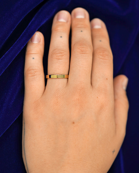 A hand wearing a 3mm band in size 6.5