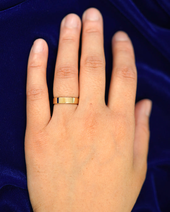 A hand wearing a 4mm band in size 4