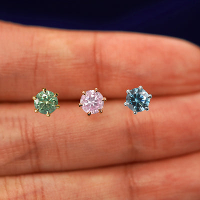 Three versions of the 5mm Moissanite Earring shown in options of yellow, white, and rose gold with three different gem colors