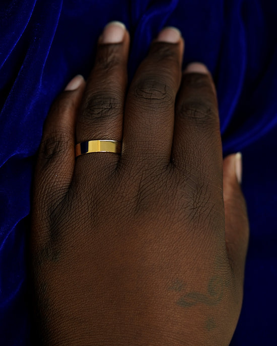 A hand wearing a 6mm band in size 14