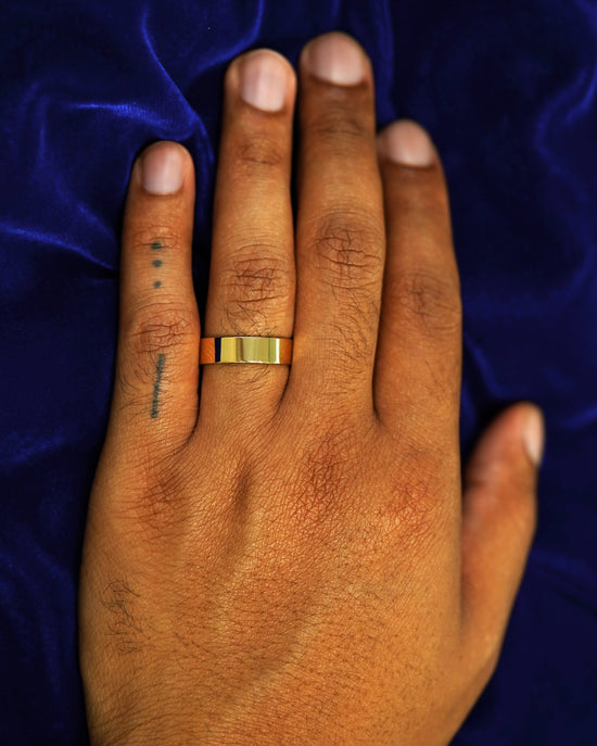A hand wearing a 6mm band in size 9