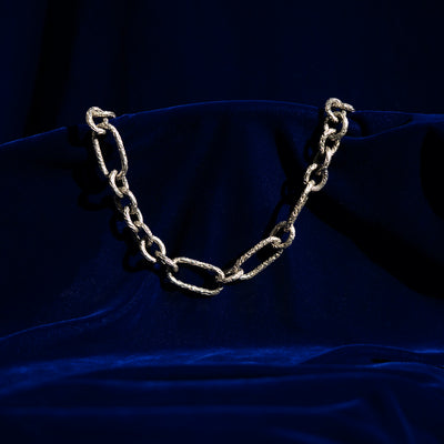 A photo of a silver chunky chain on a blue background