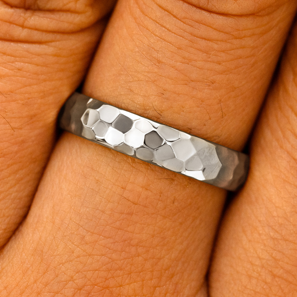 Close up view of a model's fingers wearing a Silver Curvy Hammered Band