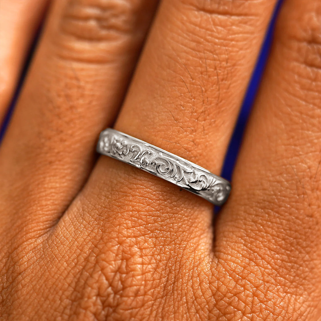 Close up view of a model's hand wearing a 925 sterling silver Filigree band