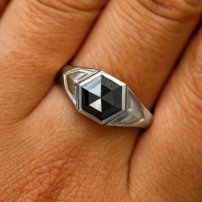 Close up view of a model's fingers wearing a 925 silver hexagon black diamond engraved transformation ring