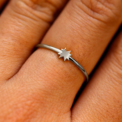 Close up view of a models fingers wearing a platinum 8 pointed star ring
