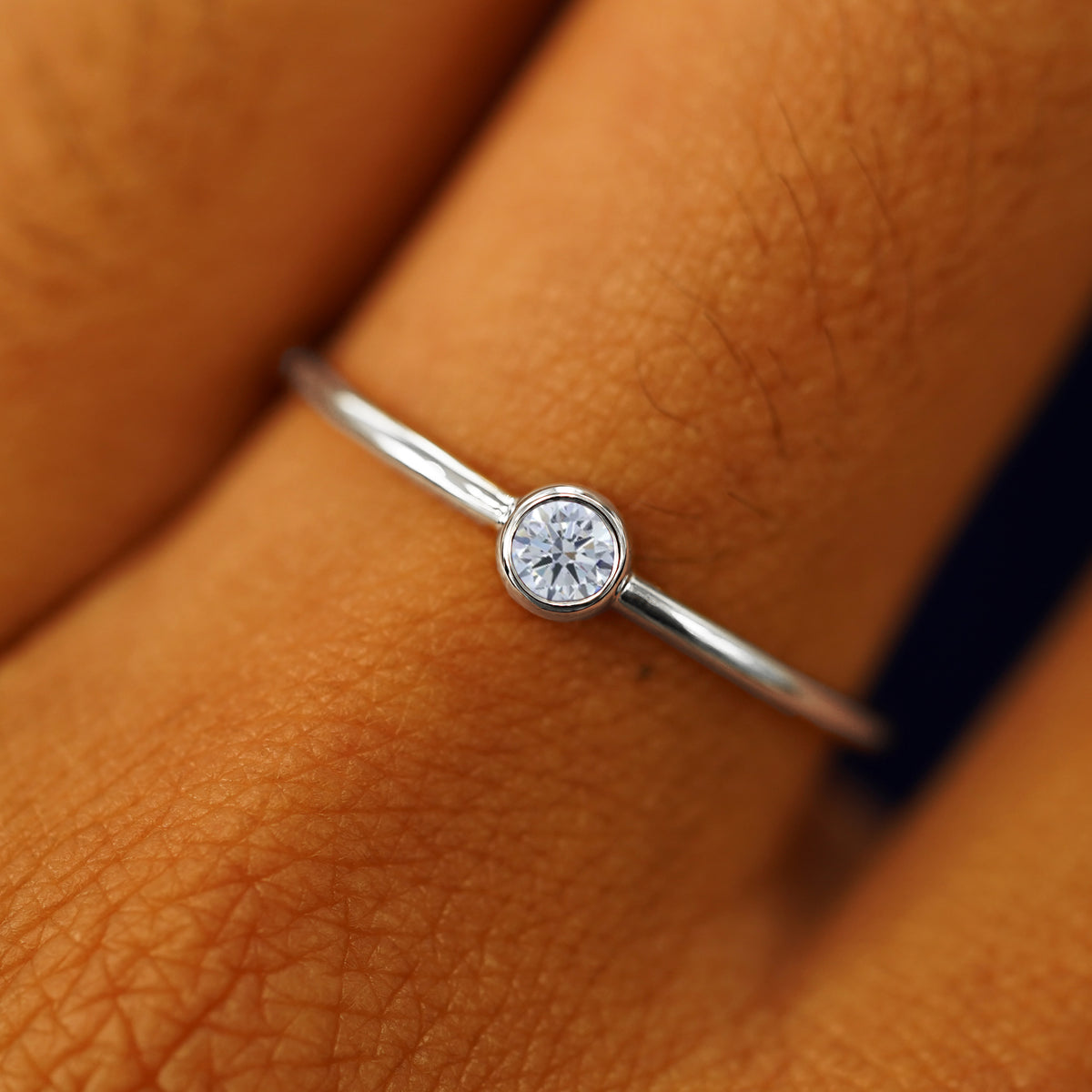 Close up view of a model's fingers wearing a 950 platinum Moissanite Ring