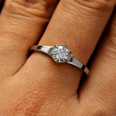 Close up view of a models fingers wearing a 950 platinum round diamond hexagon signet ring