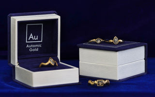 Four different salt and pepper diamond engagement rings sitting on Automic Gold ring boxes