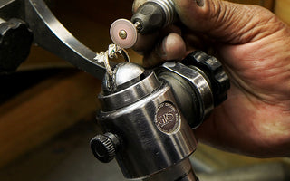 Close up view of a jewelers hands polishing a custom dragon ring