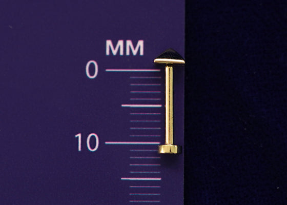 A triangle flatback lying on a millimeter ruler showing the length of the backing is 10mm