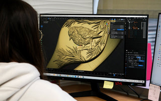 A CAD designer creating the pine and bird ring on their computer