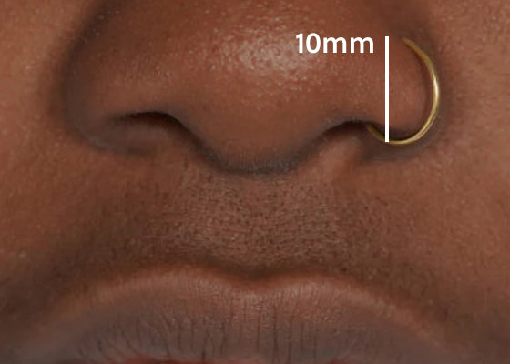 A models nose with a drawn line from the bottom of the nostril to the top of the piercing showing the distance is 10mm