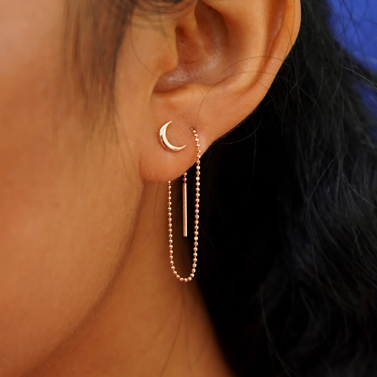A model wearing a Moon Earring with a rose gold Extender attached at the back and threaded through the front of a second piercing