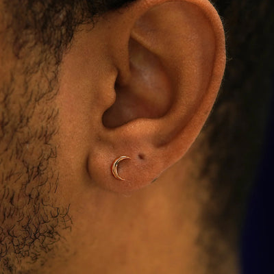Close up view of a model's ear wearing a 14k rose gold Moon Earring