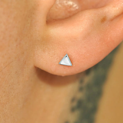 Close up view of a model's ear wearing a 14k white gold Triangle Earring
