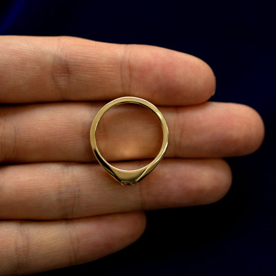A asscher moissanite signet ring laying flat in a models hand to show the thickness of  the band