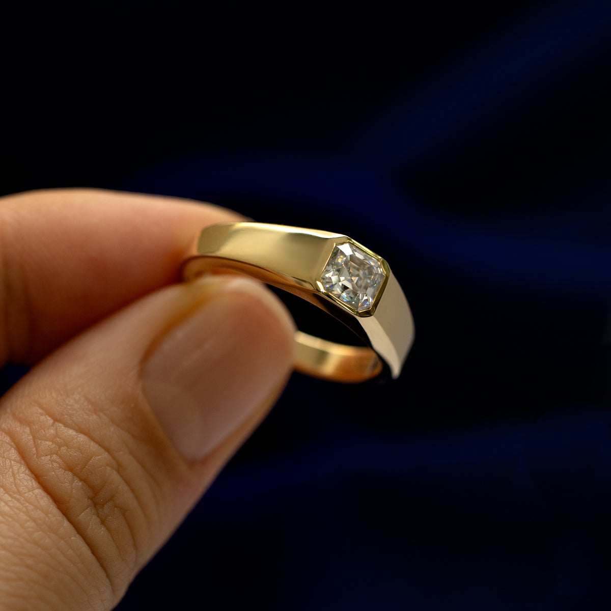 Close up view of a models hand holding a 14k white gold asscher lab gemstone ring