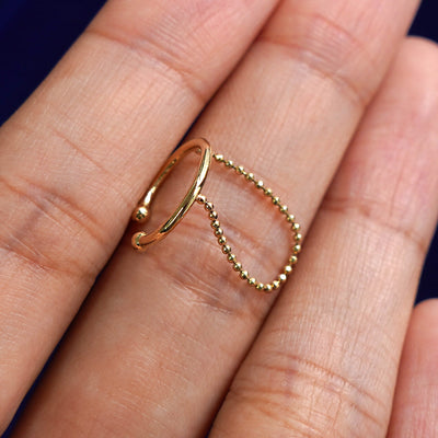 Alternate view of a solid 14 karat yellow gold Line Cuff with Chain earring resting on a model's finger