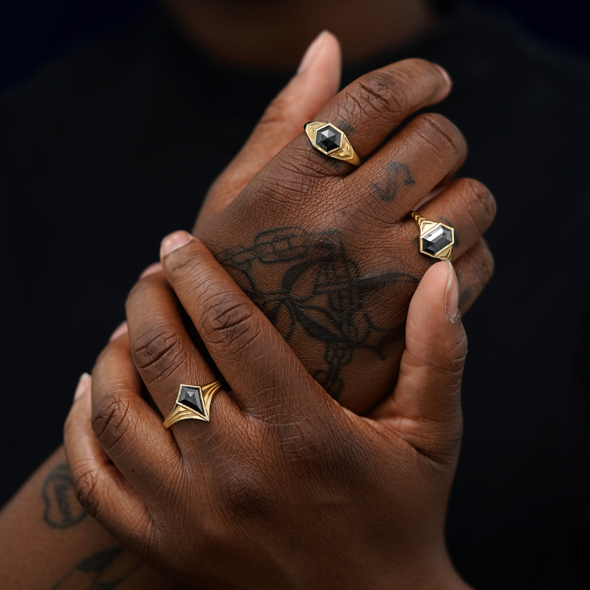 A model's right hand wearing a Journey Ring gripping their left hand that wears a Transformation Ring and a Chronos Ring