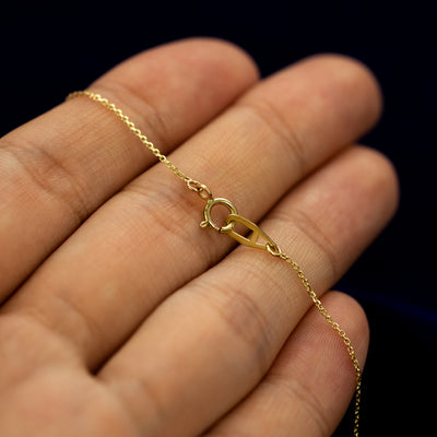 The spring ring clasp on a solid gold block initial necklace