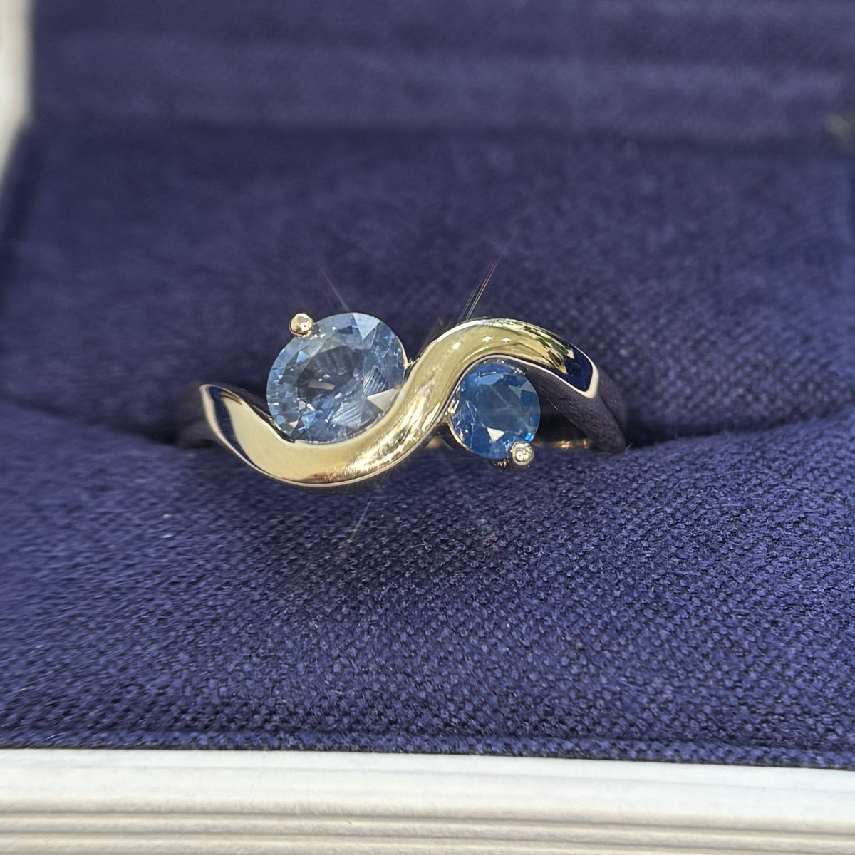 14k Yellow Gold with 0.73ct Light Blue Oval and 0.18ct Blue Round Sapphire set on 2.7mm Wavy Band Tapered to 3.7mm on the back Custom Ring, size 6.75