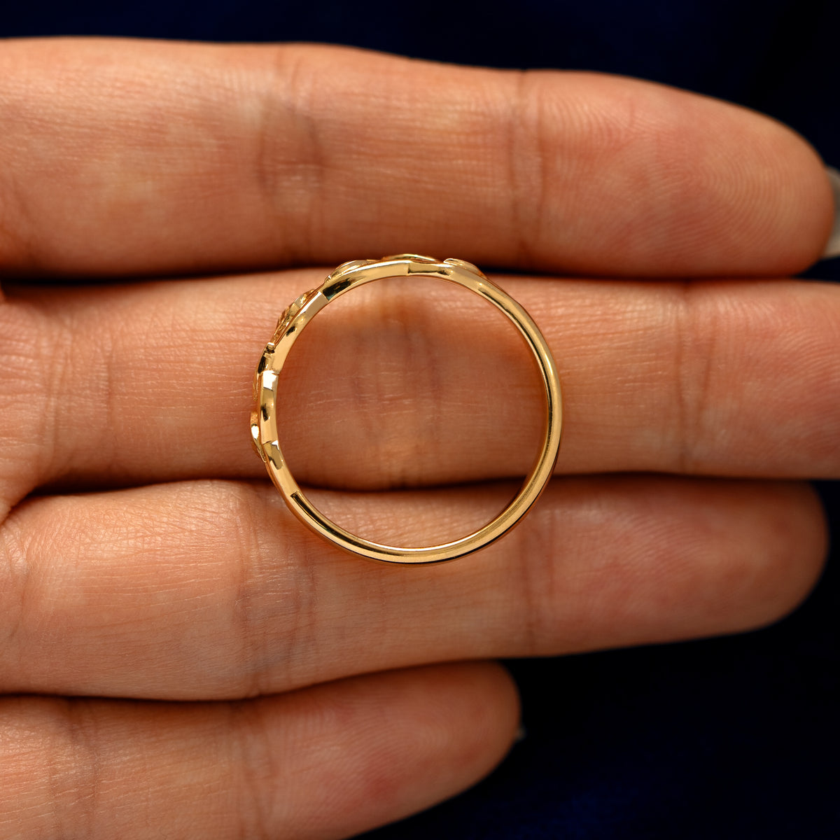 An top down  view of a Braided Leaves and Vines Ring resting on a model's fingers to show the thickness of the band