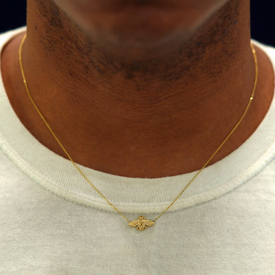 A model's neck wearing a yellow gold Bee Necklace