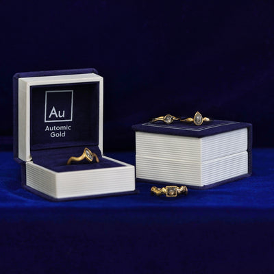 Four engagement rings with different shapes of cabochon salt and pepper diamonds with Automic Gold ring boxes