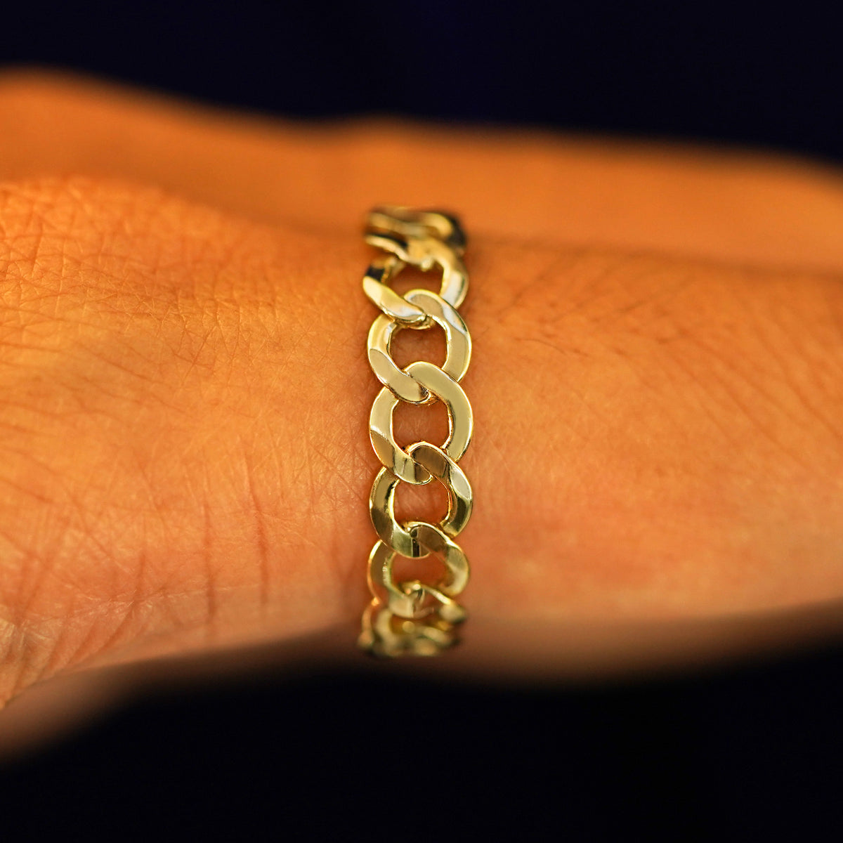 Side view of a 14k recycled yellow gold Curb Ring on a model's finger