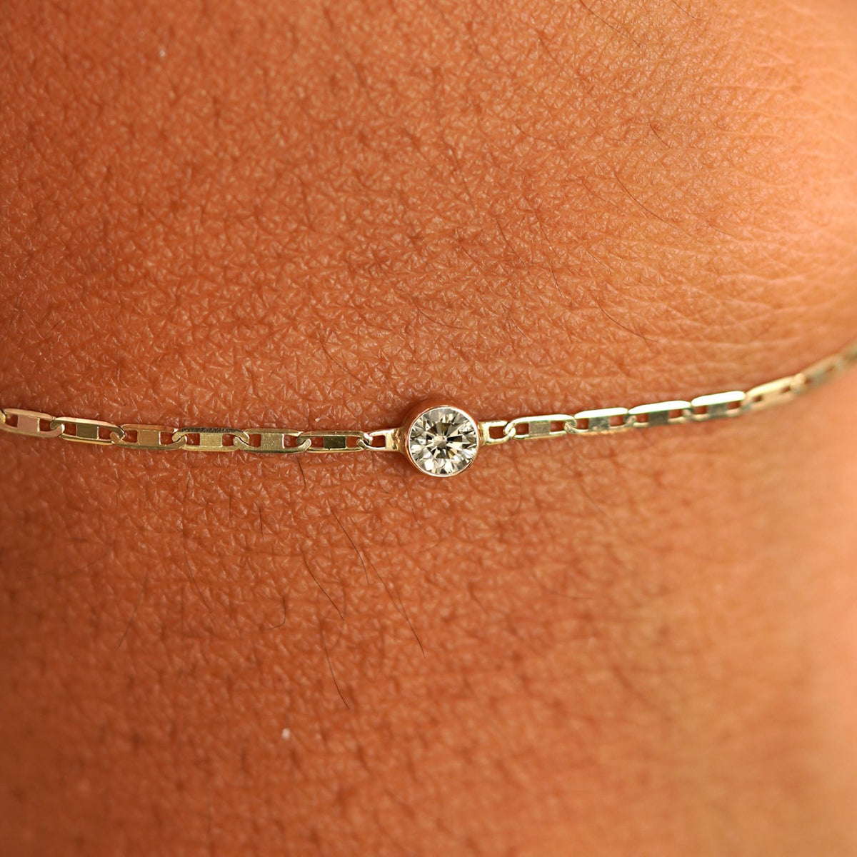 Close up view of a models wrist wearing 14k yellow gold Champagne Diamond Bracelet