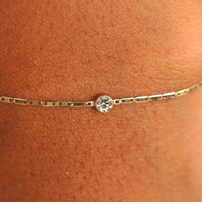 Close up view of a models wrist wearing 14k yellow gold Champagne Diamond Bracelet