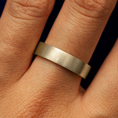 Close up view of a model's fingers wearing a 14k champagne gold Industrial Matte Band