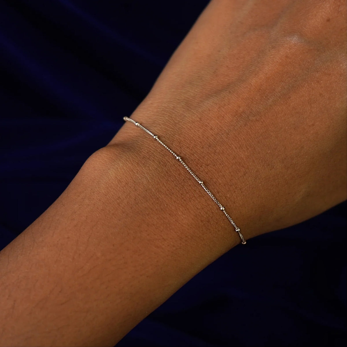 Close up view of a model's wrist wearing a champagne gold Beads Bracelet