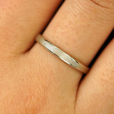 Close up view of a model's hand wearing a solid champagne gold Beveled Edge Band