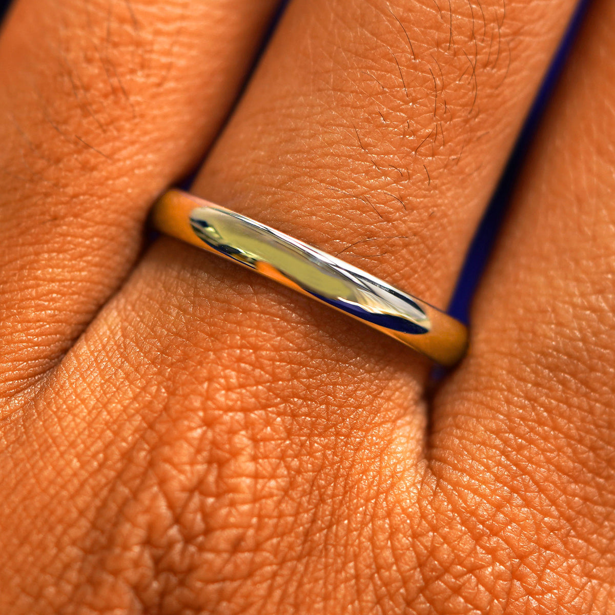 Close up view of a model's fingers wearing a 14k champagne gold Curvy Mirror Band