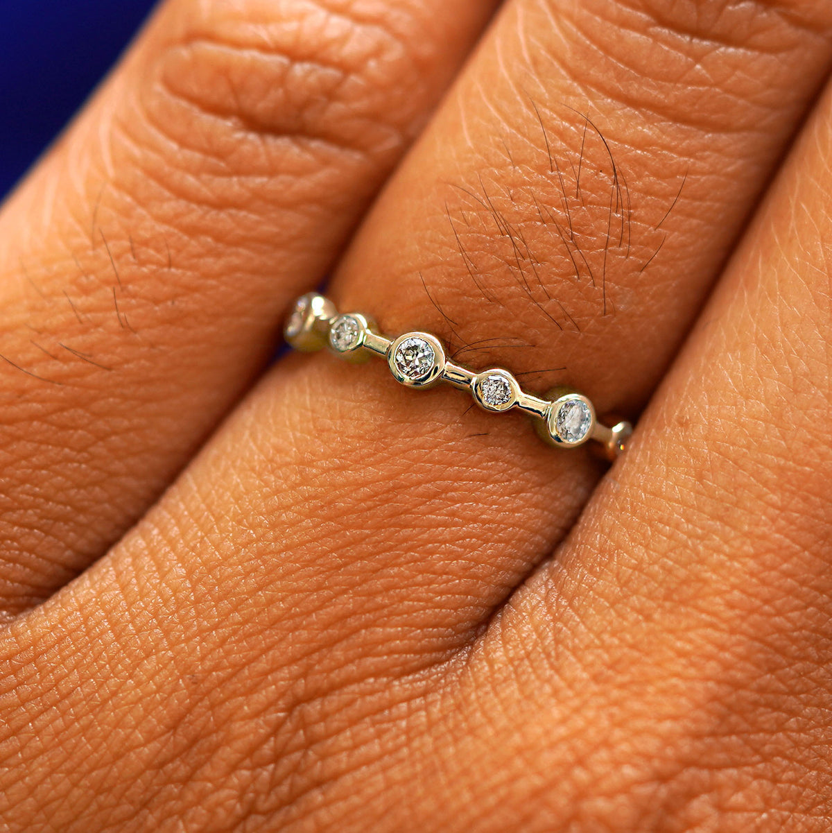 Close up view of a model's fingers wearing a 14k champagne gold Infinity Diamond Ring