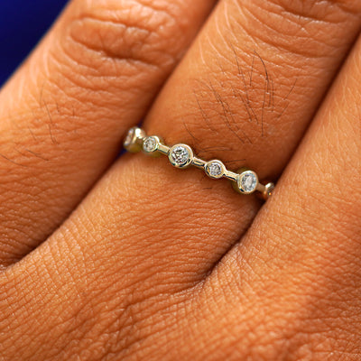 Close up view of a model's fingers wearing a 14k champagne gold Infinity Diamond Ring