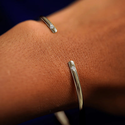 A model's wrist wearing a champagne gold Diamond Open Bangle Bracelet