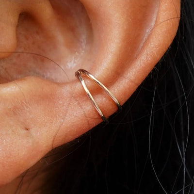 Close up view of a model's ear wearing a champagne gold Double Cuff